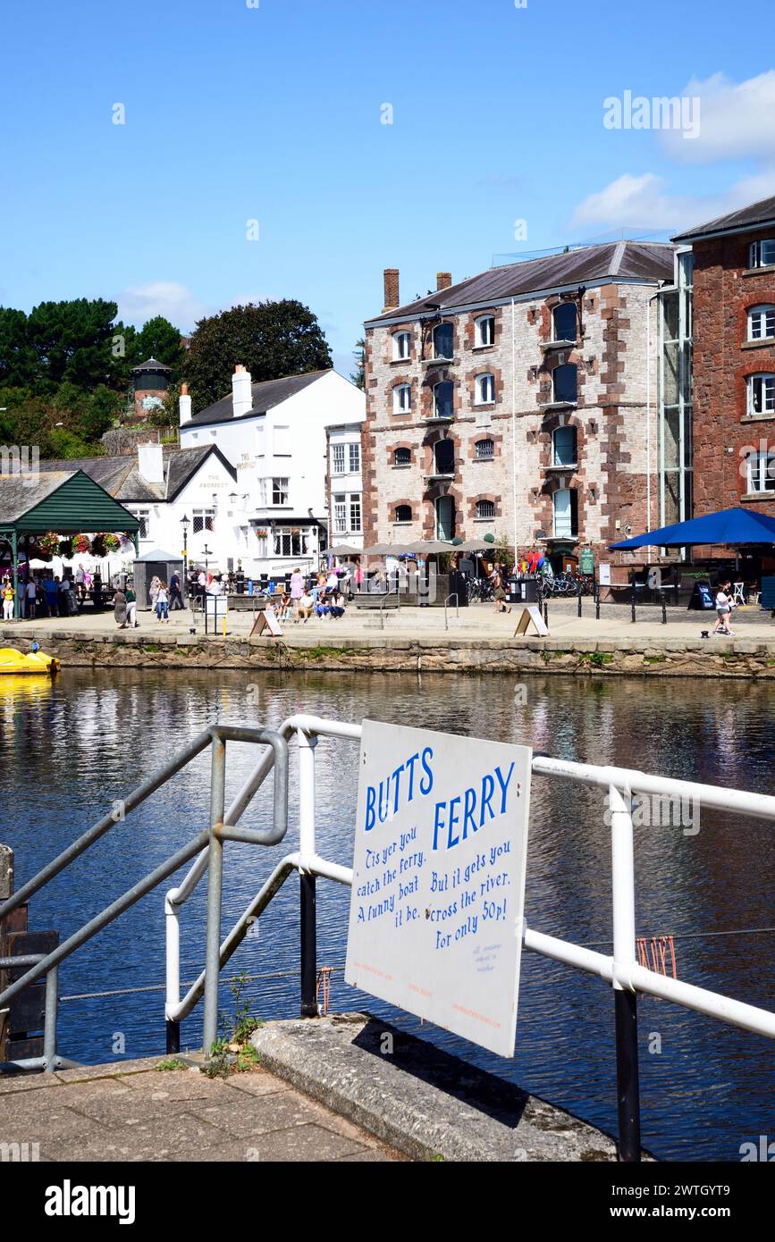 Blick über den Fluss exe in Richtung der Geschäfte und Restaurants entlang des East Quay mit Butts Ferry Station im Vordergrund, Exeter, Devon, Großbritannien, Europa. Stockfoto