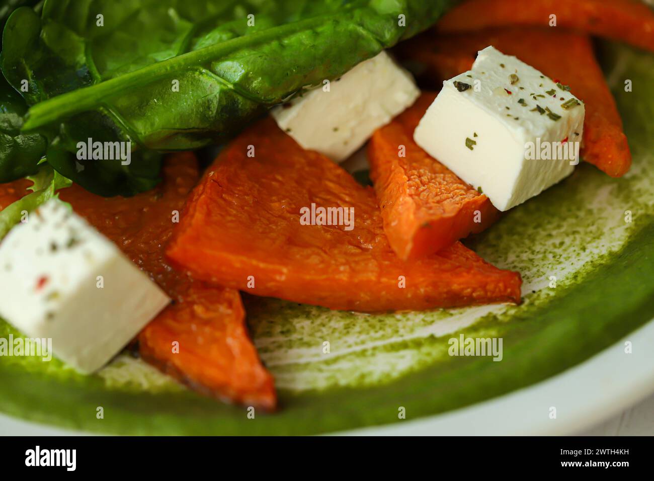 Salat aus Kürbis, Spinat, Fetakäse und Kirschtomaten. Garniert mit Sauce. Keto-Diät. Kopierbereich Stockfoto