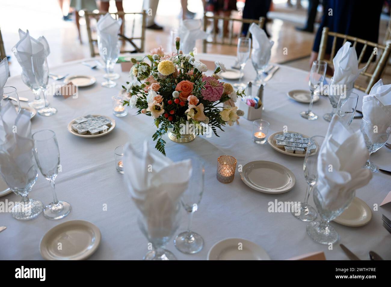 Eleganter weißer Tisch mit üppigen Blumenarrangements Stockfoto