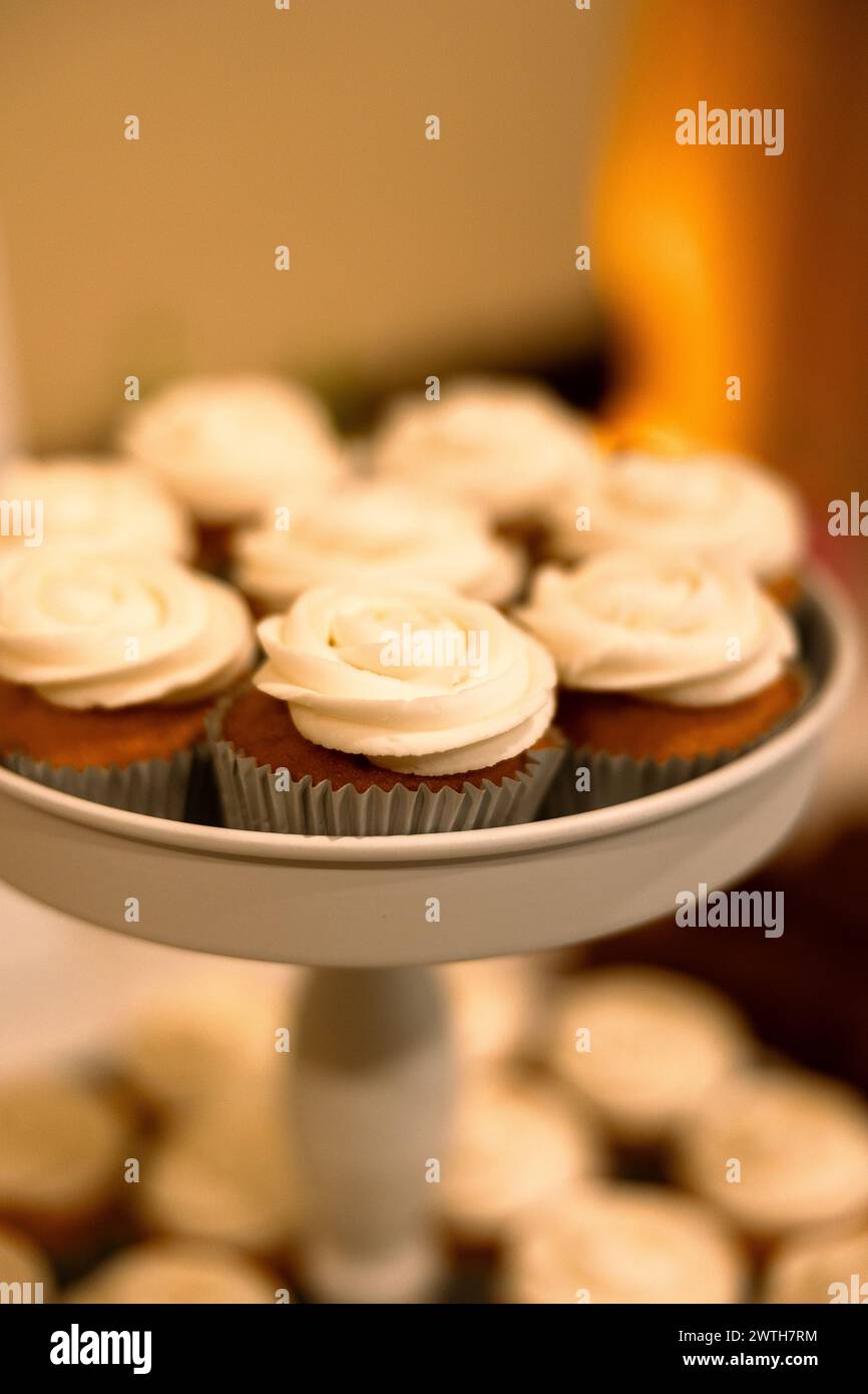 Elegante weiße Cupcakes auf einer mehrstufigen Anzeige Stockfoto