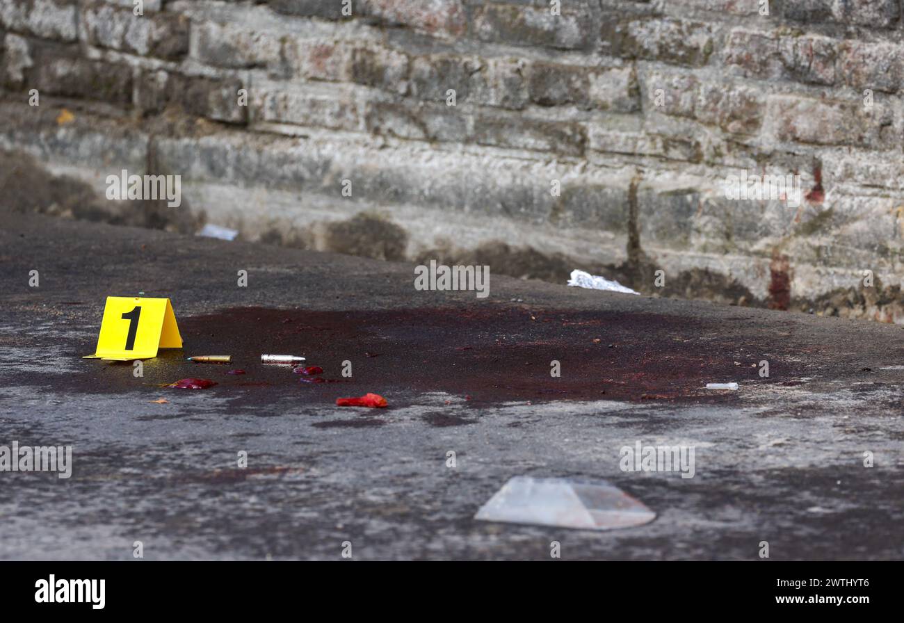 Charleroi, Belgien. März 2024. ACHTUNG REDAKTEURE: GRAFIKINHALTE - BLUT IM BILD - Bullet Cases werden neben einer Beweisnummer am Tatort einer Polizeioperation in Lodelinsart, Charleroi, am Sonntag, den 17. März 2024, gesehen. Eine Hausdurchsuchung eskalierte am frühen Montagmorgen, als der Bewohner begann, auf Polizisten zu schießen. Ein Mitglied der Sonderpolizei ist gestorben und mehrere wurden verletzt. Der Angreifer wurde angeblich neutralisiert. BELGA PHOTO VIRGINIE LEFOUR Credit: Belga News Agency/Alamy Live News Stockfoto