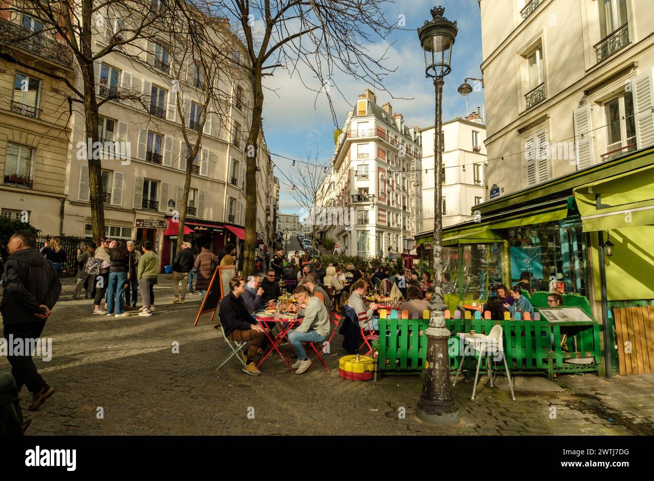 Paris, Frankreich - 17. Februar 2024 : Blick auf die Menschen, die draußen sitzen und in einem Restaurant-Bistro in Montmartre Paris Frankreich Abendessen und Getränke genießen Stockfoto