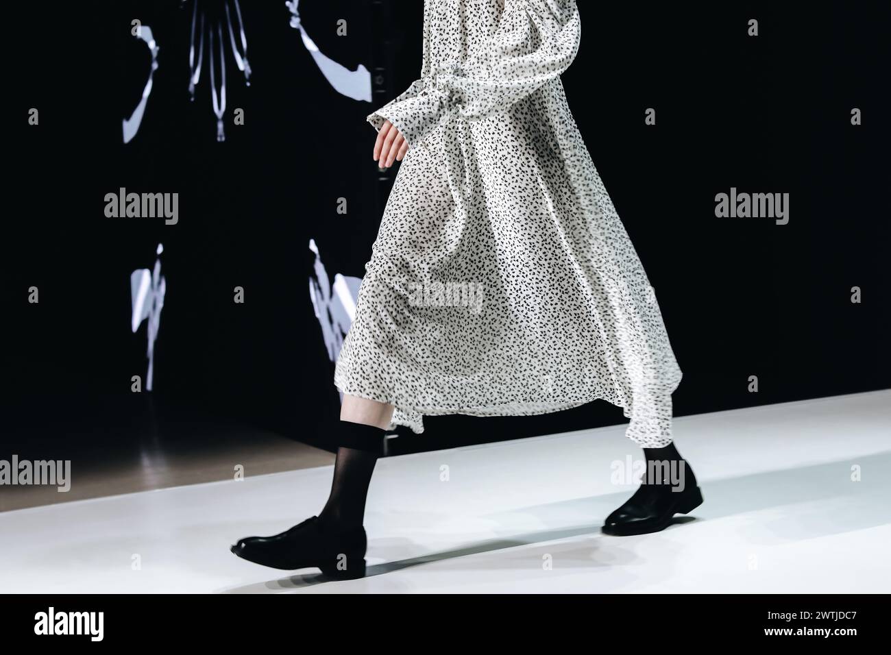 Stilvolles langes weißes Kleid und schwarze Schuhe Freizeitmode für Damen. Seitenansicht. Modische Details Stockfoto