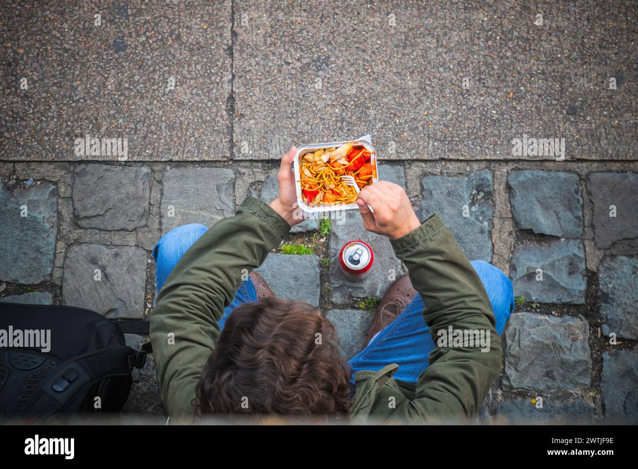 Konzept, Blick von oben auf einen Touristen, der auf der Straße auf dem Camden Market in London chinesisches Essen isst Stockfoto
