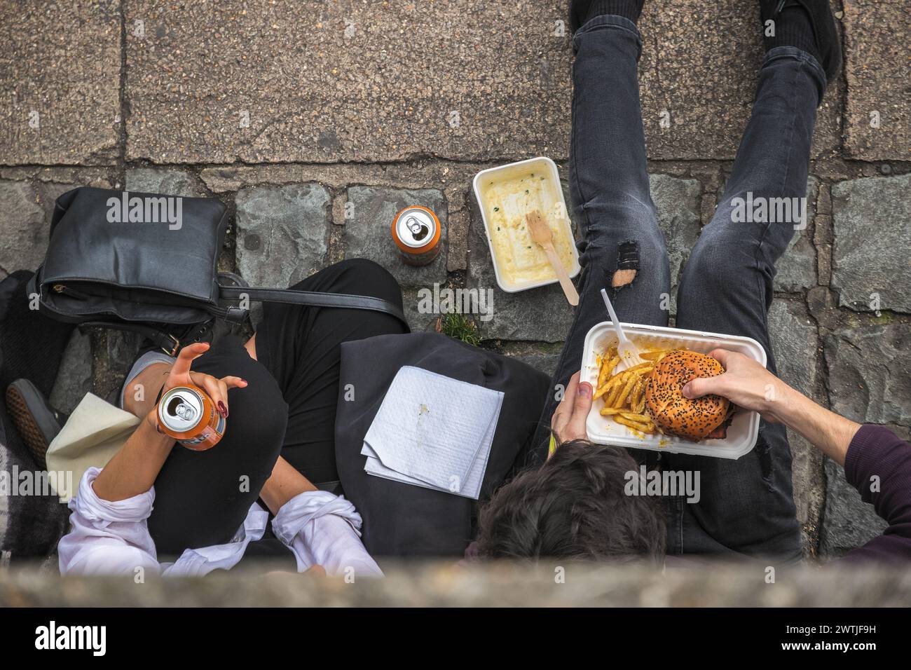 Blick von oben auf zwei Personen, die auf der Straße am Camden Market zum Mitnehmen essen Stockfoto