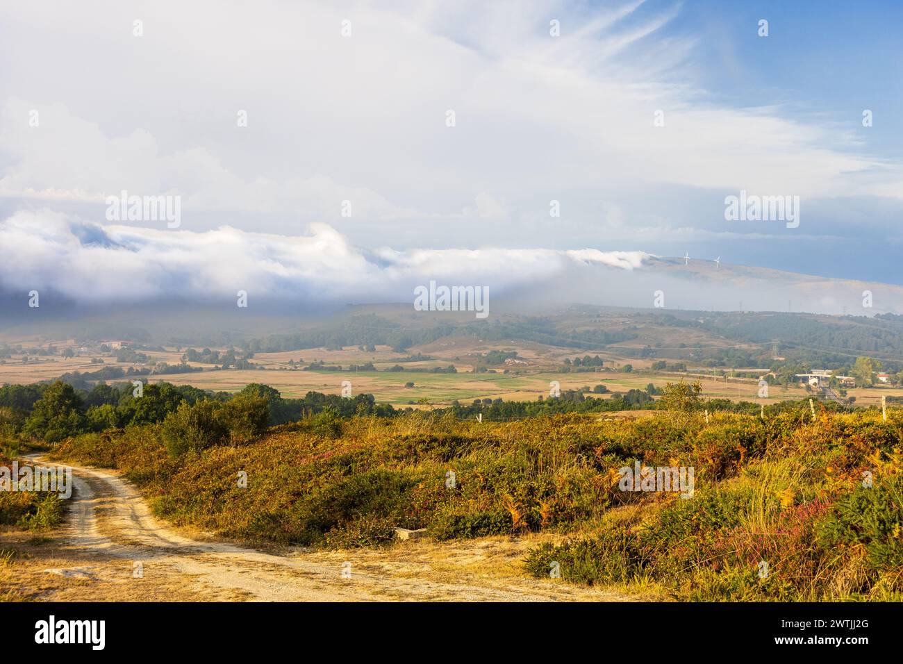 Tief liegende Wolken, die sich von den Bergen über das Tal schleichen. Mirador de Cabañas de Virtus. Region Las Merindades, Provinz Burgos, Spanien. Stockfoto