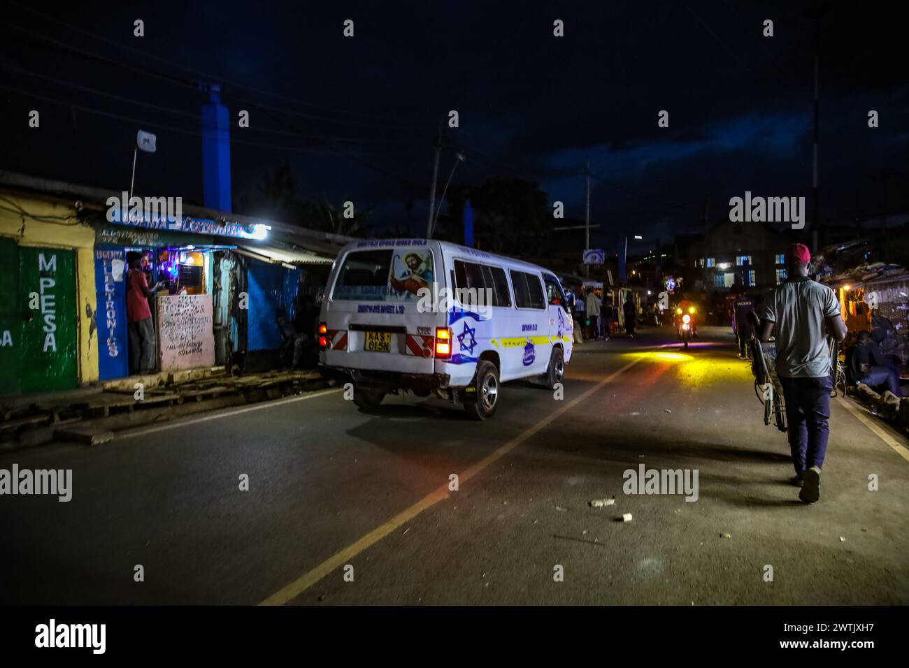 Autofahrer fahren durch die geschäftige Soweto West Road in Kibera Slum. Kibera, der größte Slum in Nairobi und Afrika, beherbergt mehr als eine Million Einwohner Stockfoto
