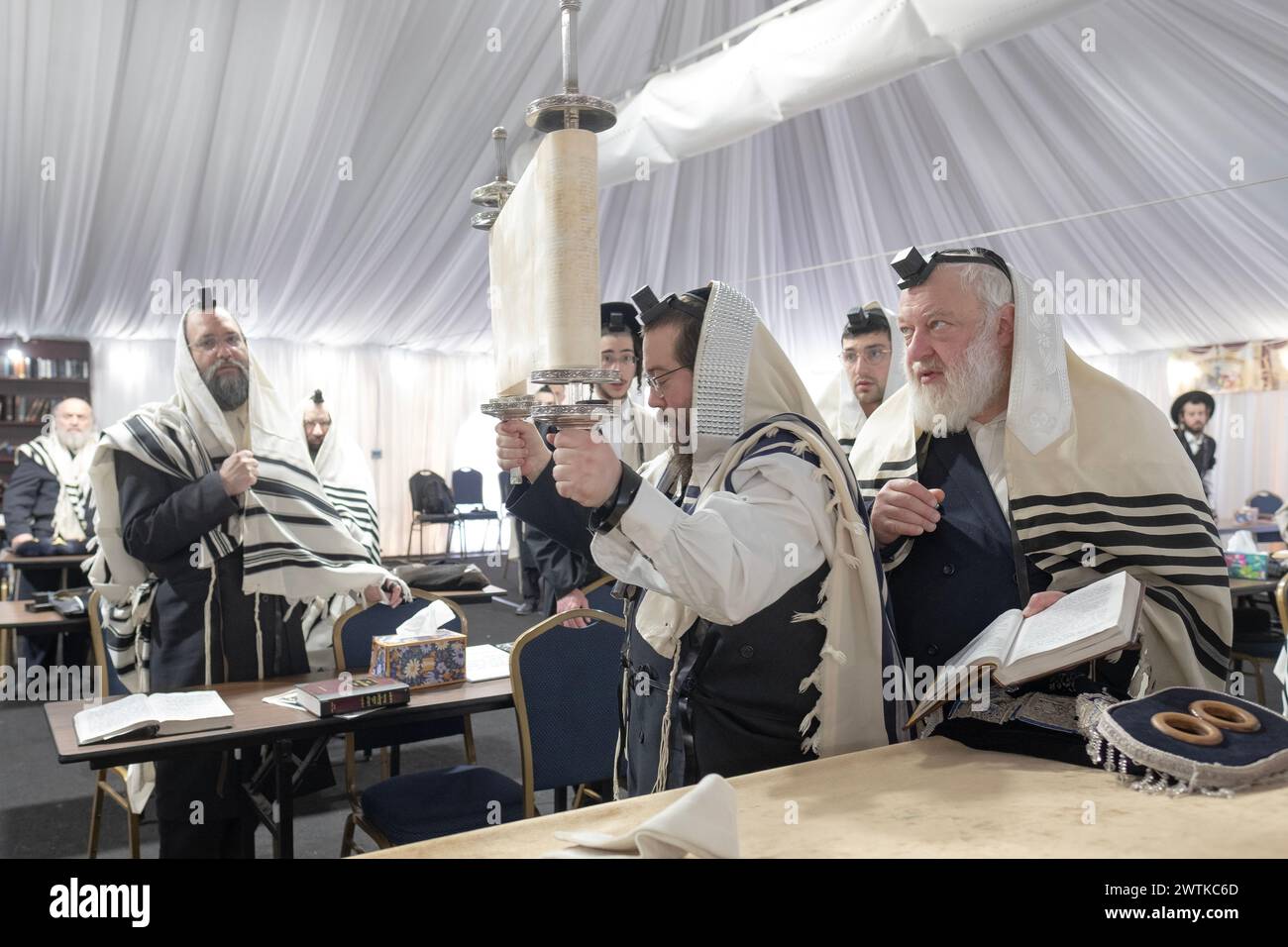 Nach einer Lesung wird eine Tora erhoben und alle, die sich die Buchstaben ansehen, sind gesegnet. In einer Synagoge in Monsey, New York. Stockfoto