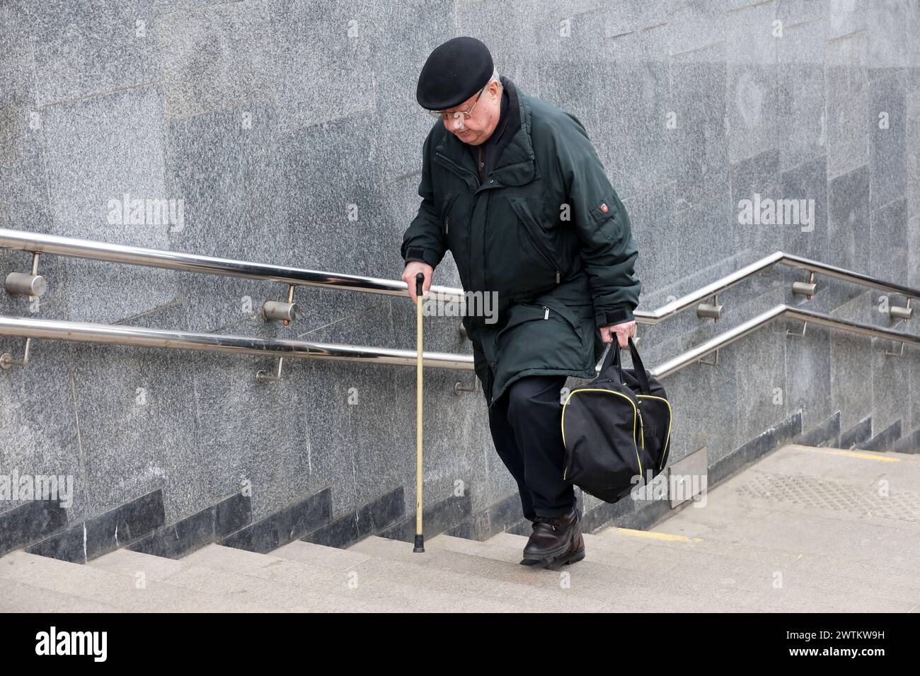 Mann mit Gehstock, der Treppen auf der Stadtstraße klettert Stockfoto