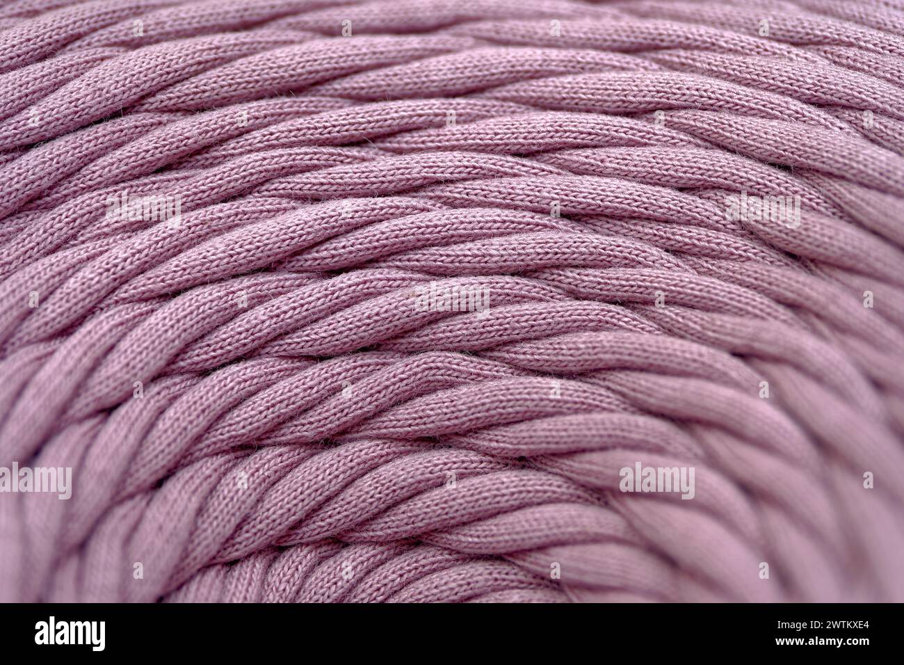 Knäuel aus rosa geflochtener synthetischer Schnur, Nahaufnahme, selektiver Fokus, abstrakter Textilindustrie Hintergrund Stockfoto