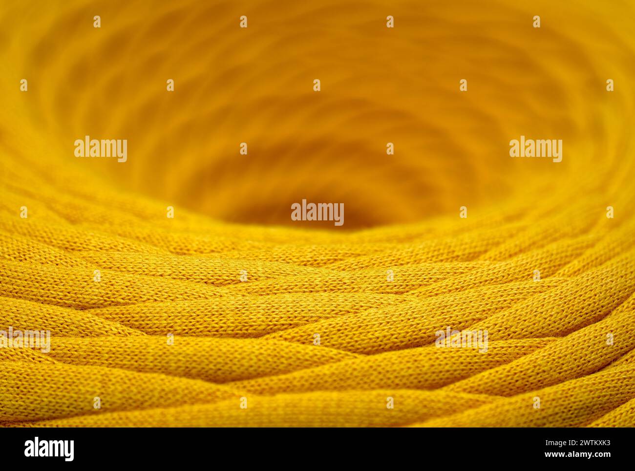 Knäuel aus gelber geflochtener synthetischer Schnur, Nahaufnahme, selektiver Fokus, abstrakter Hintergrund der Textilindustrie Stockfoto