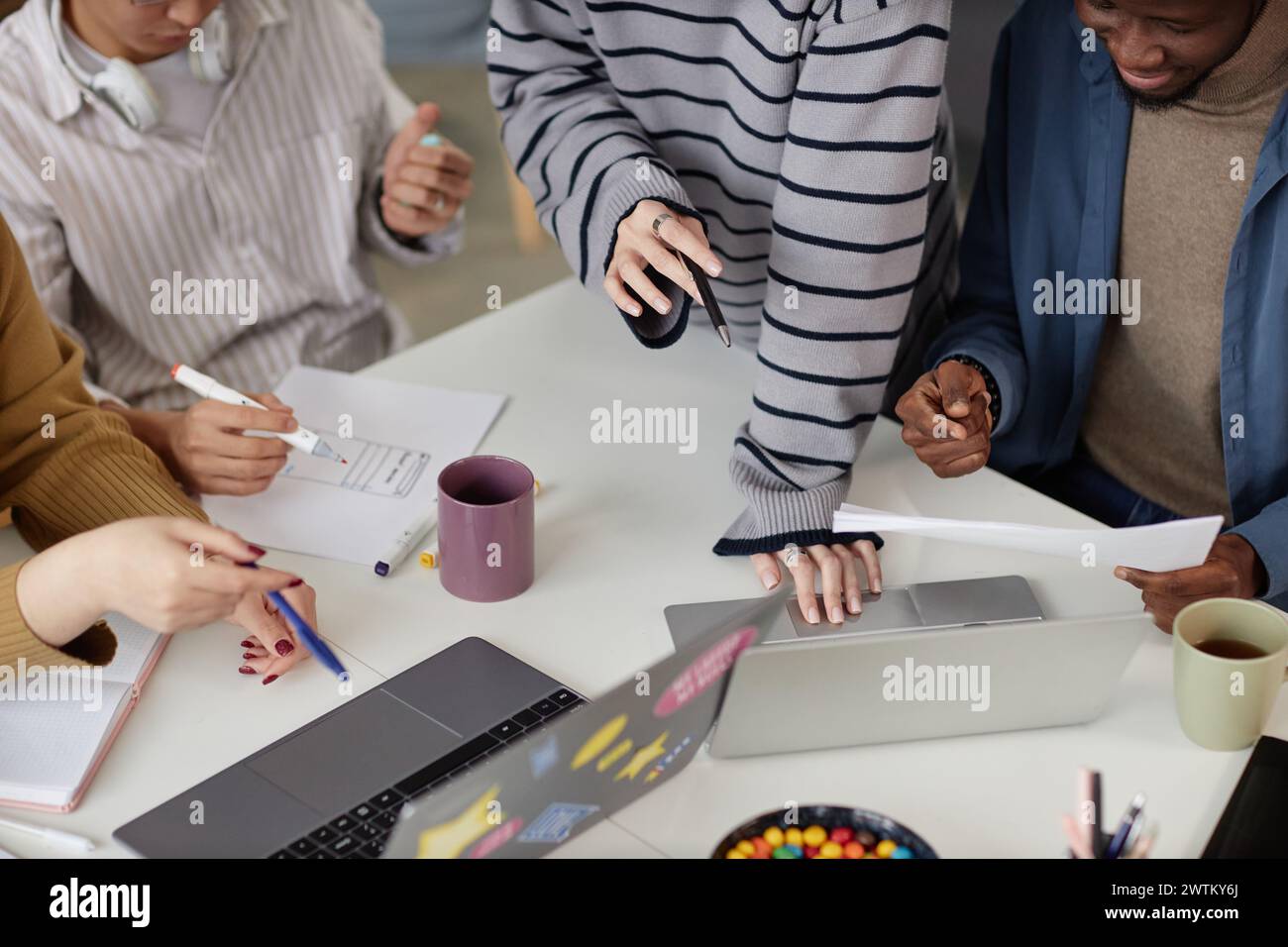 Nahaufnahme eines jungen Geschäftsteams, das über einem Meeting-Tisch arbeitet und mit einem Laptop arbeitet Stockfoto