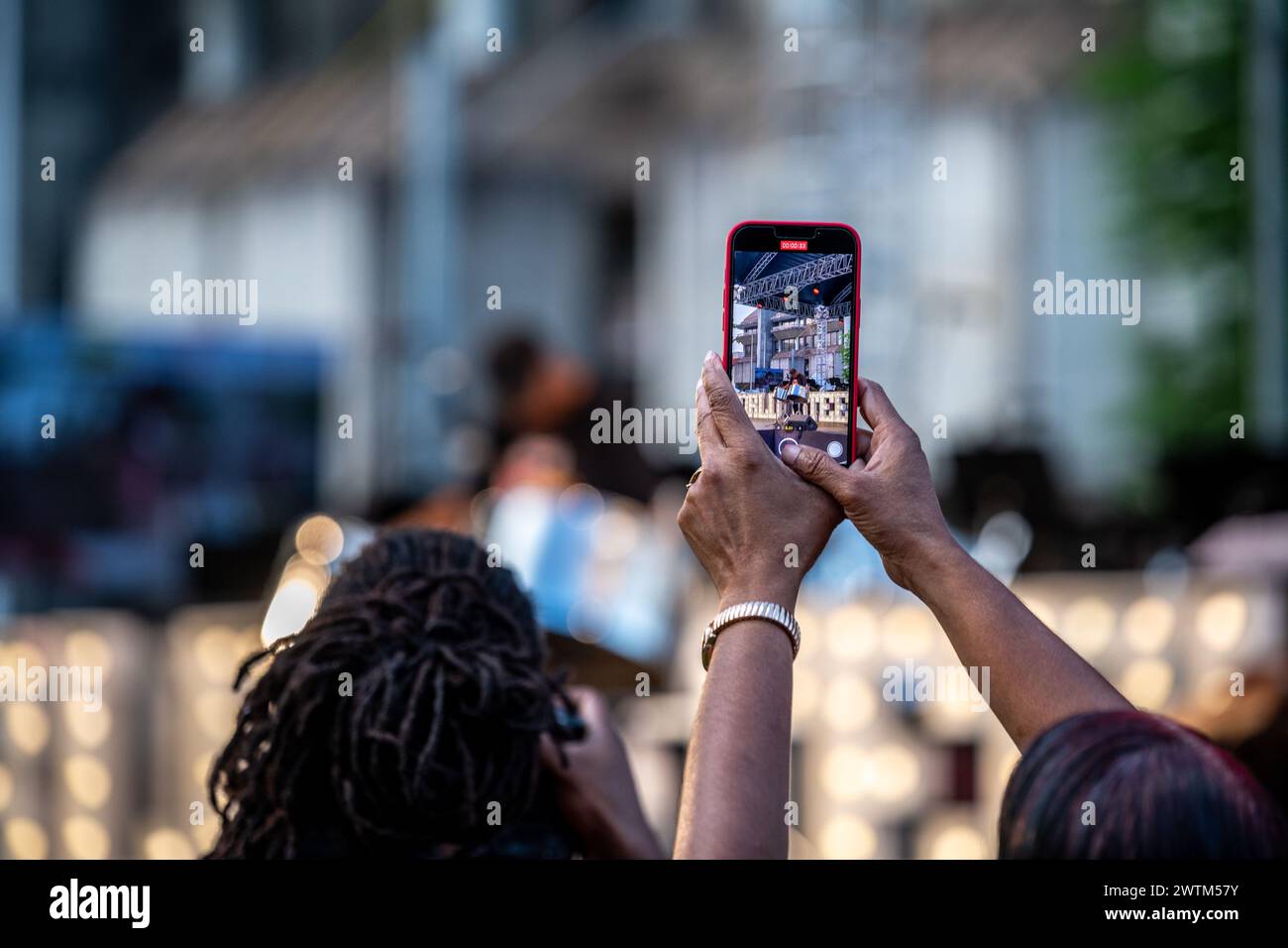 Frau, die ein Foto vom World Steel Pan Day Konzert in Trinidad und Tobago macht Stockfoto