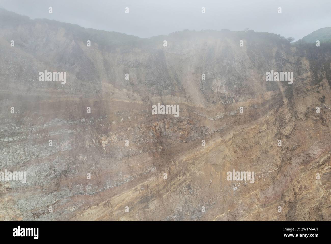 Felsiger Stein Vulkanhügel in rauchiger Himmelsbeleuchtung mit Drohnenblick Stockfoto