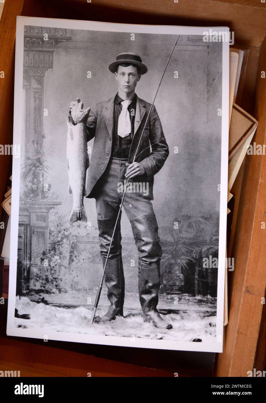 Ein Atelierporträt eines Amerikaners, der eine Angelstange und einen Fisch hält, wurde Anfang der 1900er Jahre in einem Antiquitätenladen zum Verkauf gestellt. Stockfoto