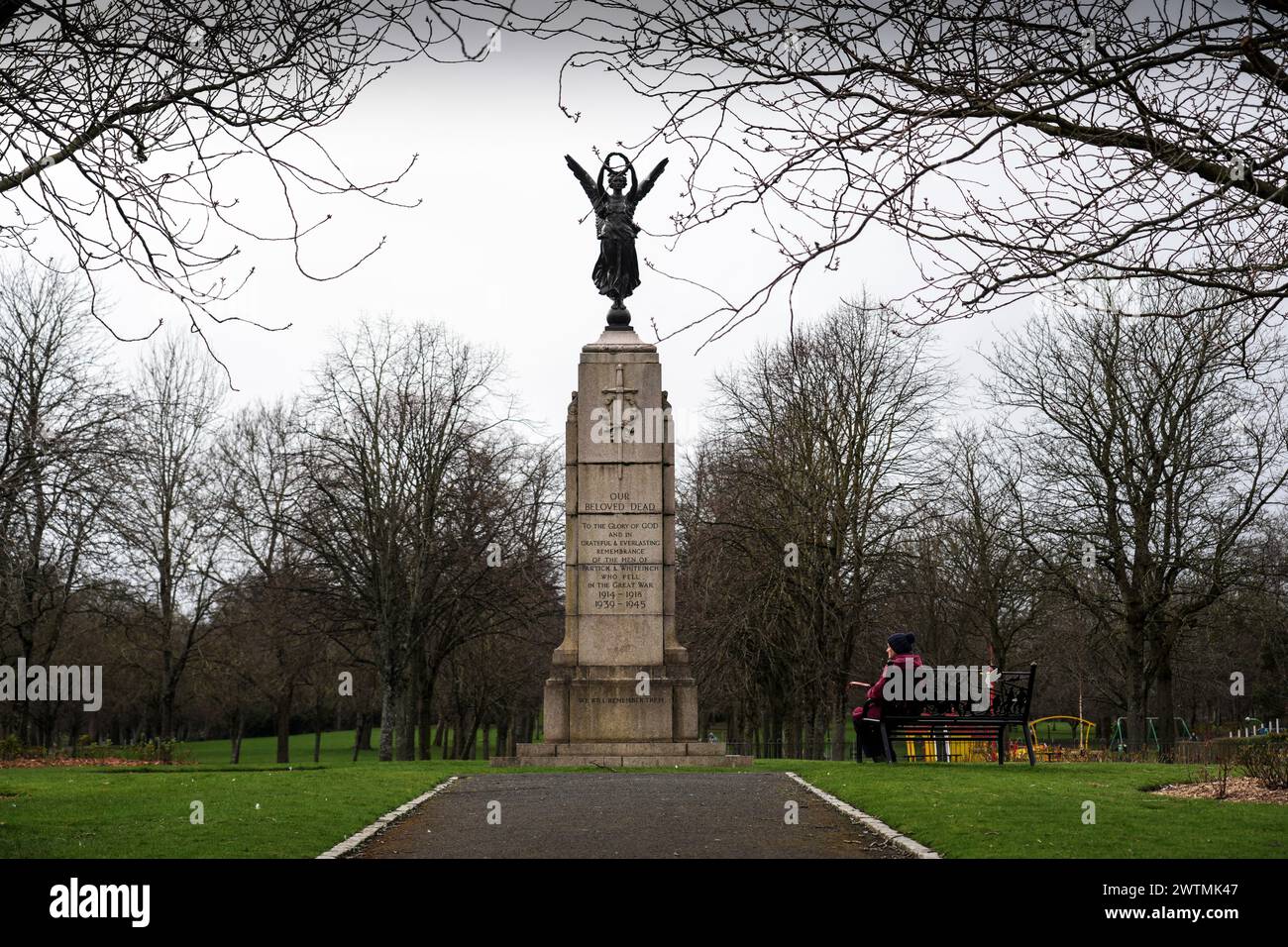 Eine Person sitzt am Partick and Whiteinch war Memorial in Victoria Park, Glasgow, Schottland, das 1922 errichtet wurde. Stockfoto