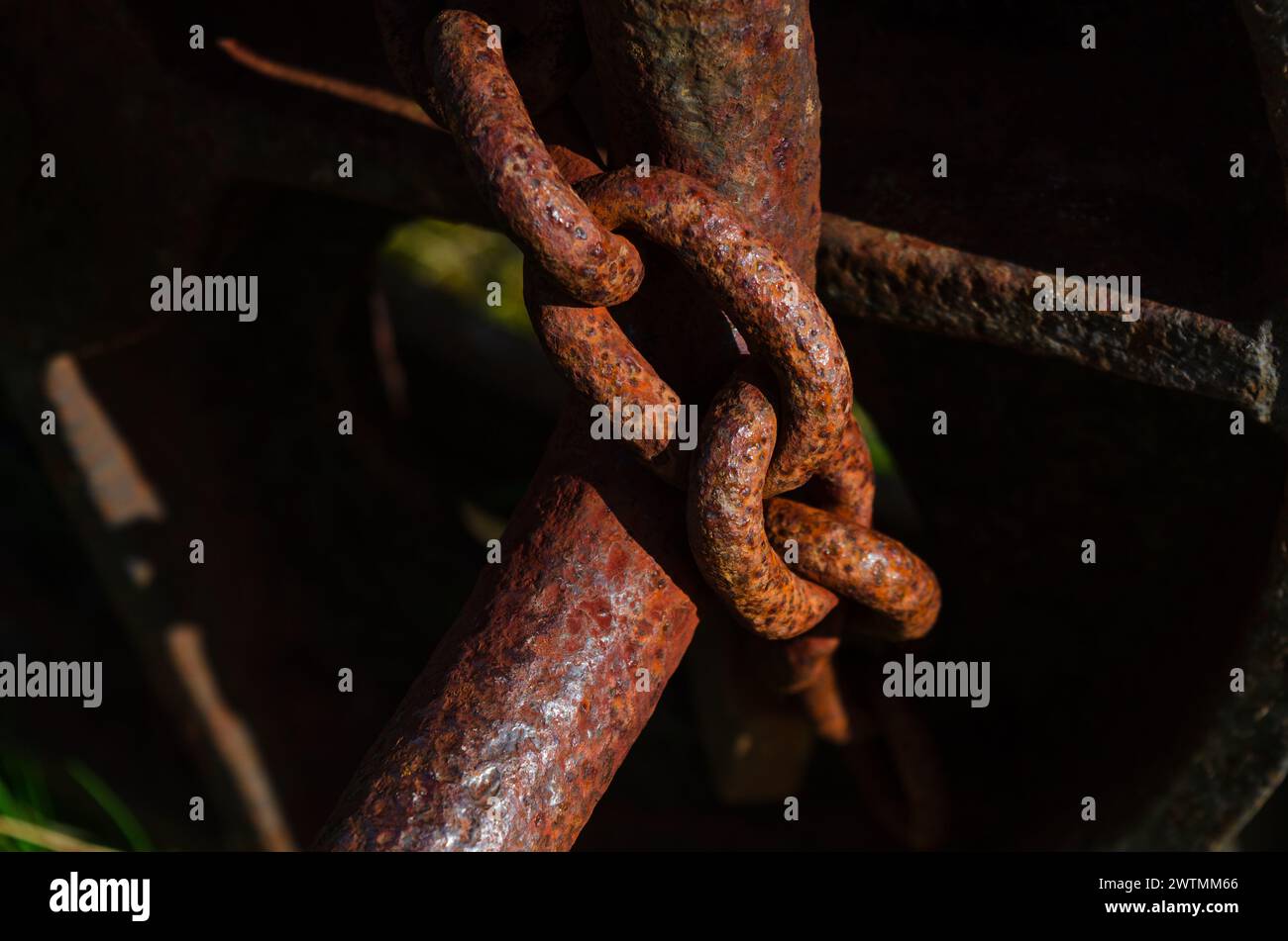 Nahaufnahme einer verrosteten Kette, die eine alte Maschine aus Sicherheitsgründen sichert Stockfoto