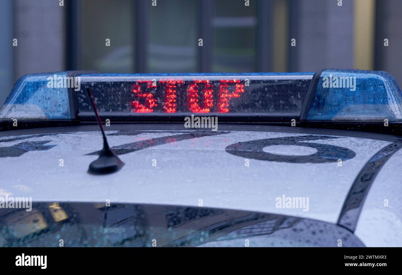 Hamburg, Deutschland. März 2024. Das Wort „Stop“ steht neben dem blauen Licht auf dem Dach eines Polizeiwagens. Quelle: Marcus Brandt/dpa/Alamy Live News Stockfoto