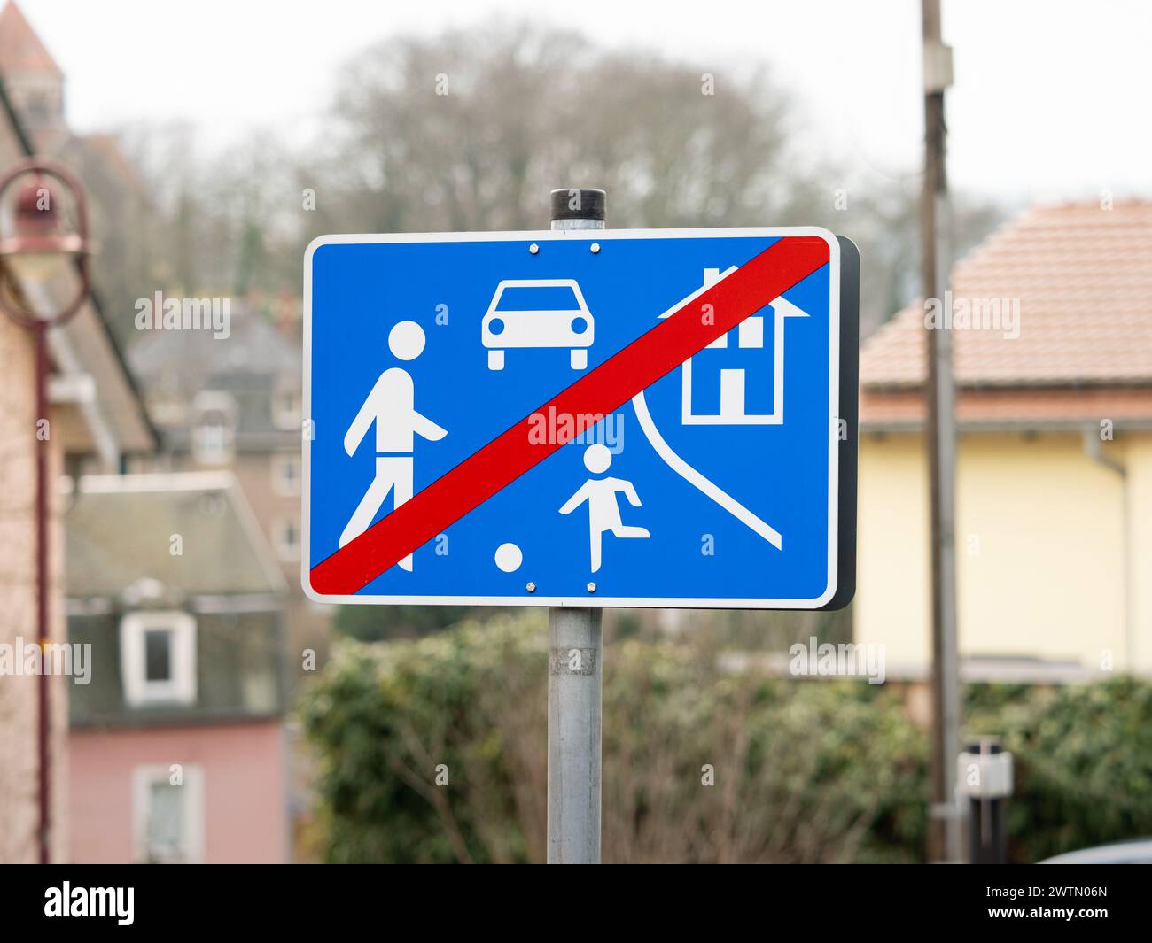 Ende eines lebendigen Straßenschildes in einem Wohnviertel. Verkehrssymbol beim Verlassen eines Bereichs mit spielenden Kindern auf der Straße. Ende der Geschwindigkeitsbegrenzungszone Stockfoto