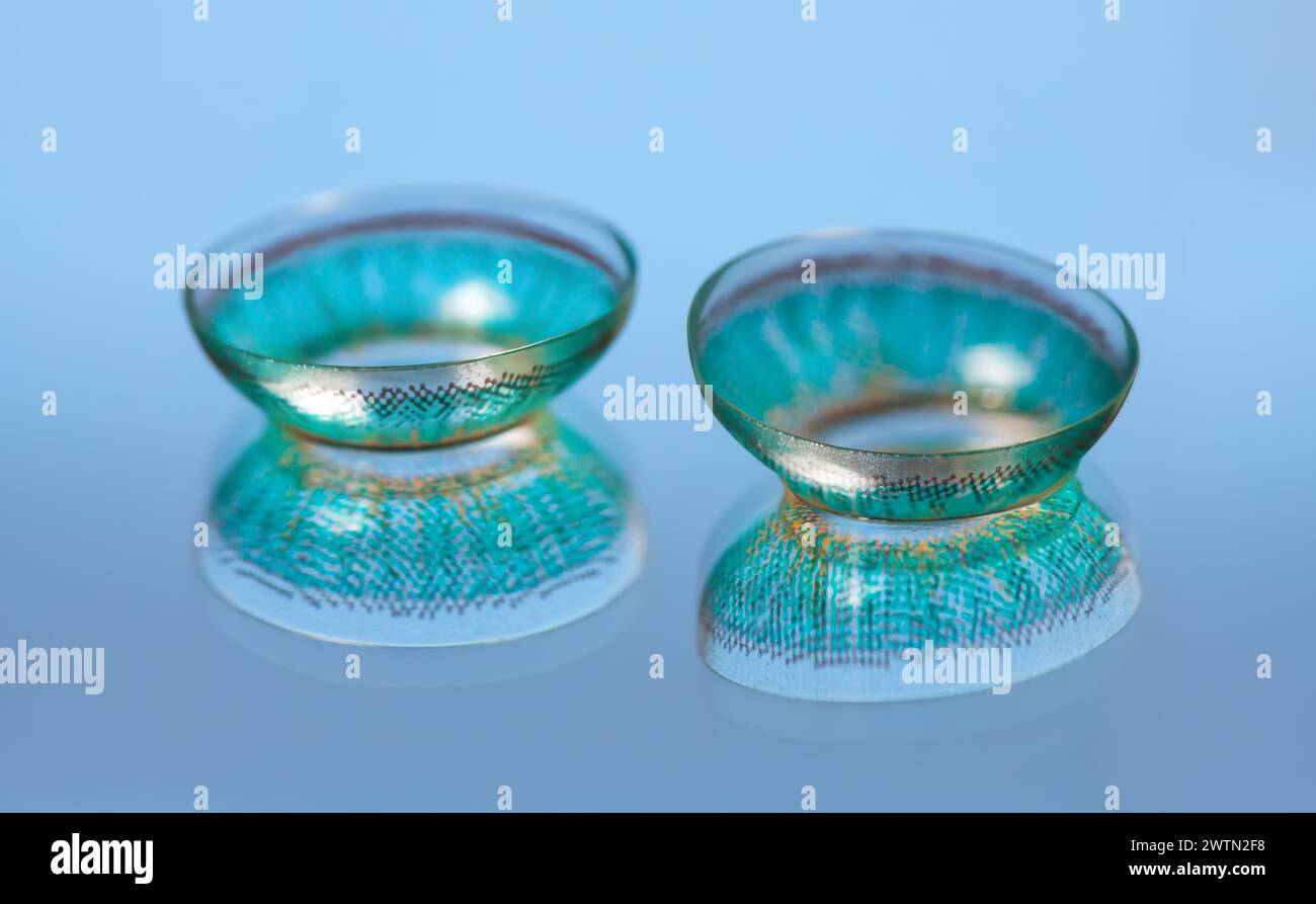 Ein Paar blaue Kontaktlinsen befindet sich auf blauem Hintergrund. Stockfoto