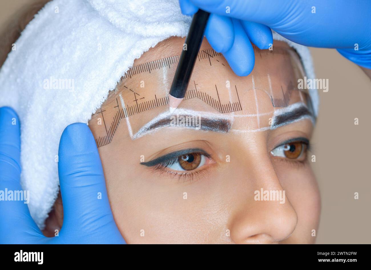 Permanent Make-up für Augenbrauen einer schönen Frau mit dicken Augenbrauen im Schönheitssalon. Nahaufnahme-Kosmetikerin, die Augenbrauen tätowiert. Stockfoto