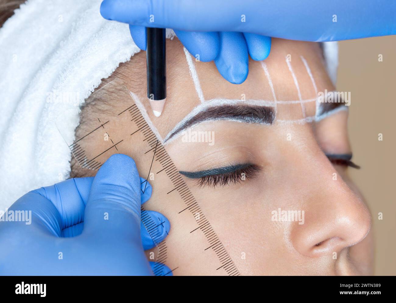 Permanent Make-up für Augenbrauen einer schönen Frau mit dicken Augenbrauen im Schönheitssalon. Nahaufnahme-Kosmetikerin, die Augenbrauen tätowiert. Stockfoto