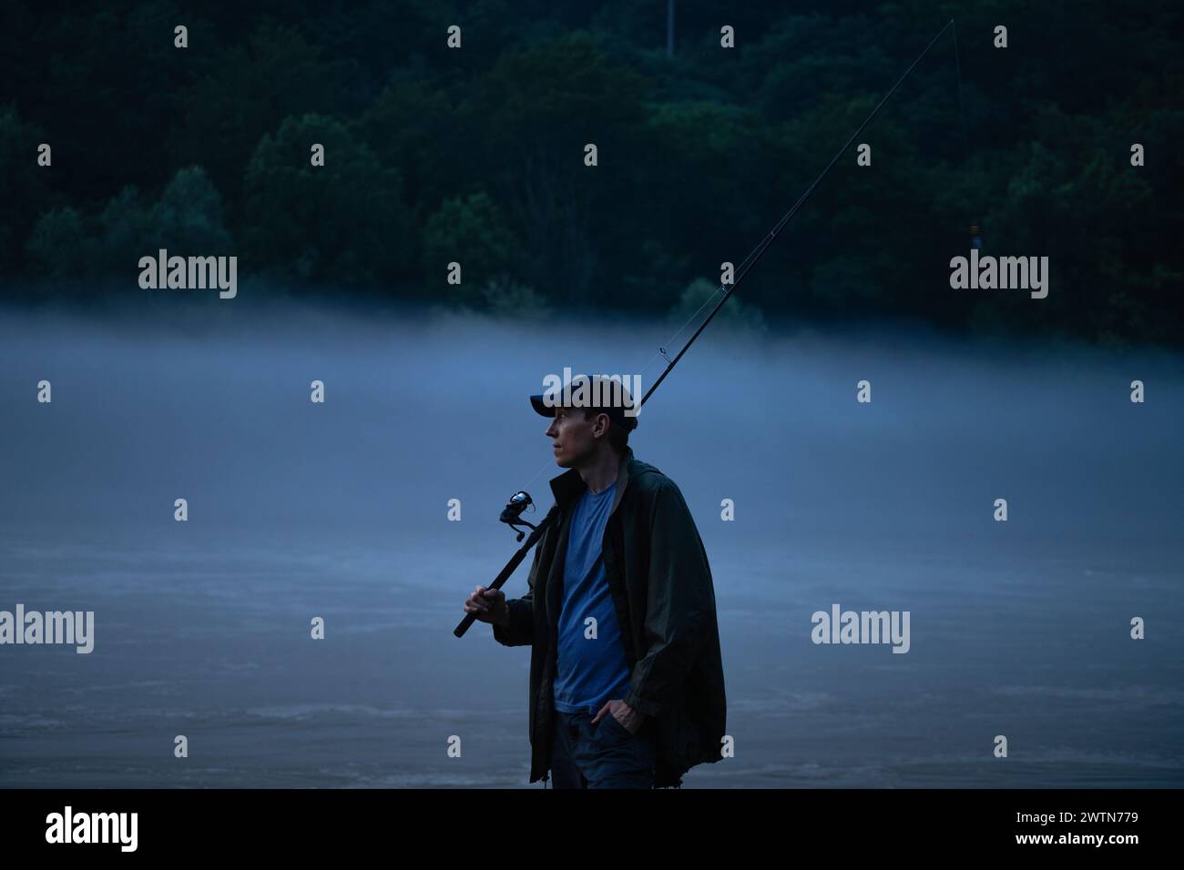 Mann fischt am Abend auf dem Bergfluss. Stockfoto