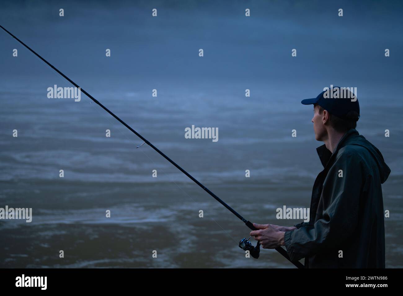 Mann fischt am Abend auf dem Bergfluss. Stockfoto