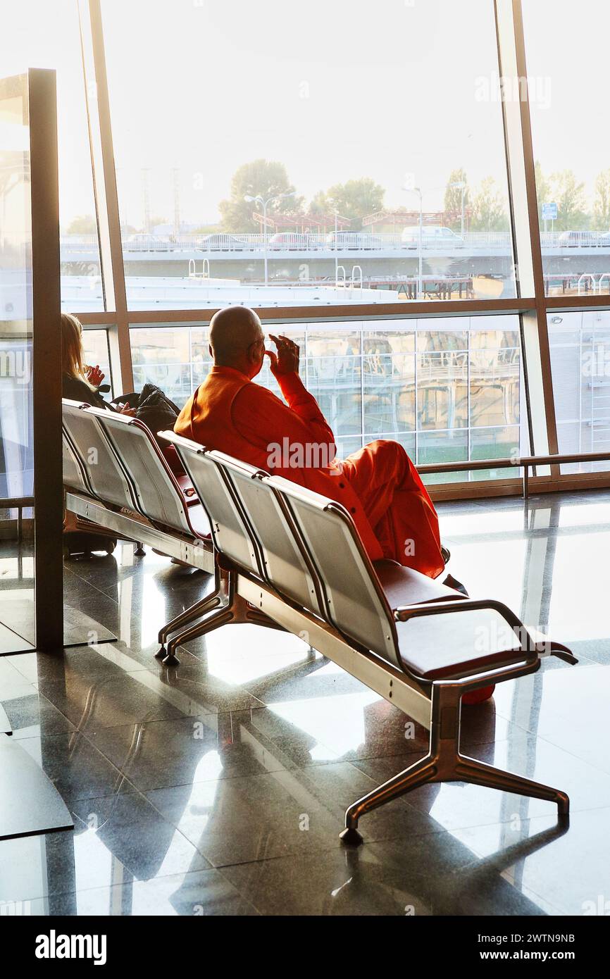 Buddist Mönch wartet auf den Flug im Flughafen Almaty (Kasachstan) an einem schönen Septembertag 2018 Stockfoto