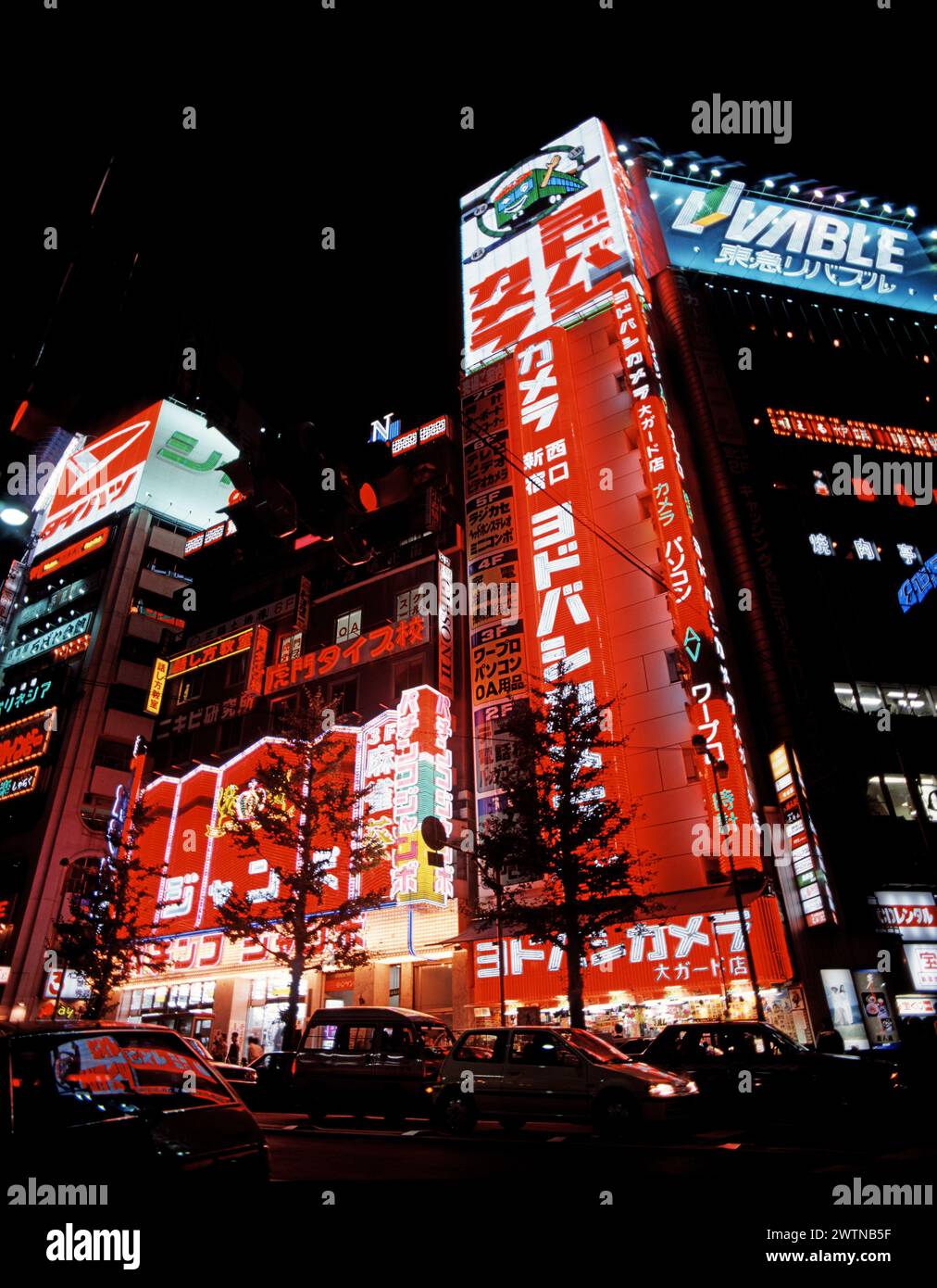 Japan. Tokio. Bezirk Shinjuku. Geschäftige Straßenszene mit hellen Lichtern und Verkehr bei Nacht. Stockfoto