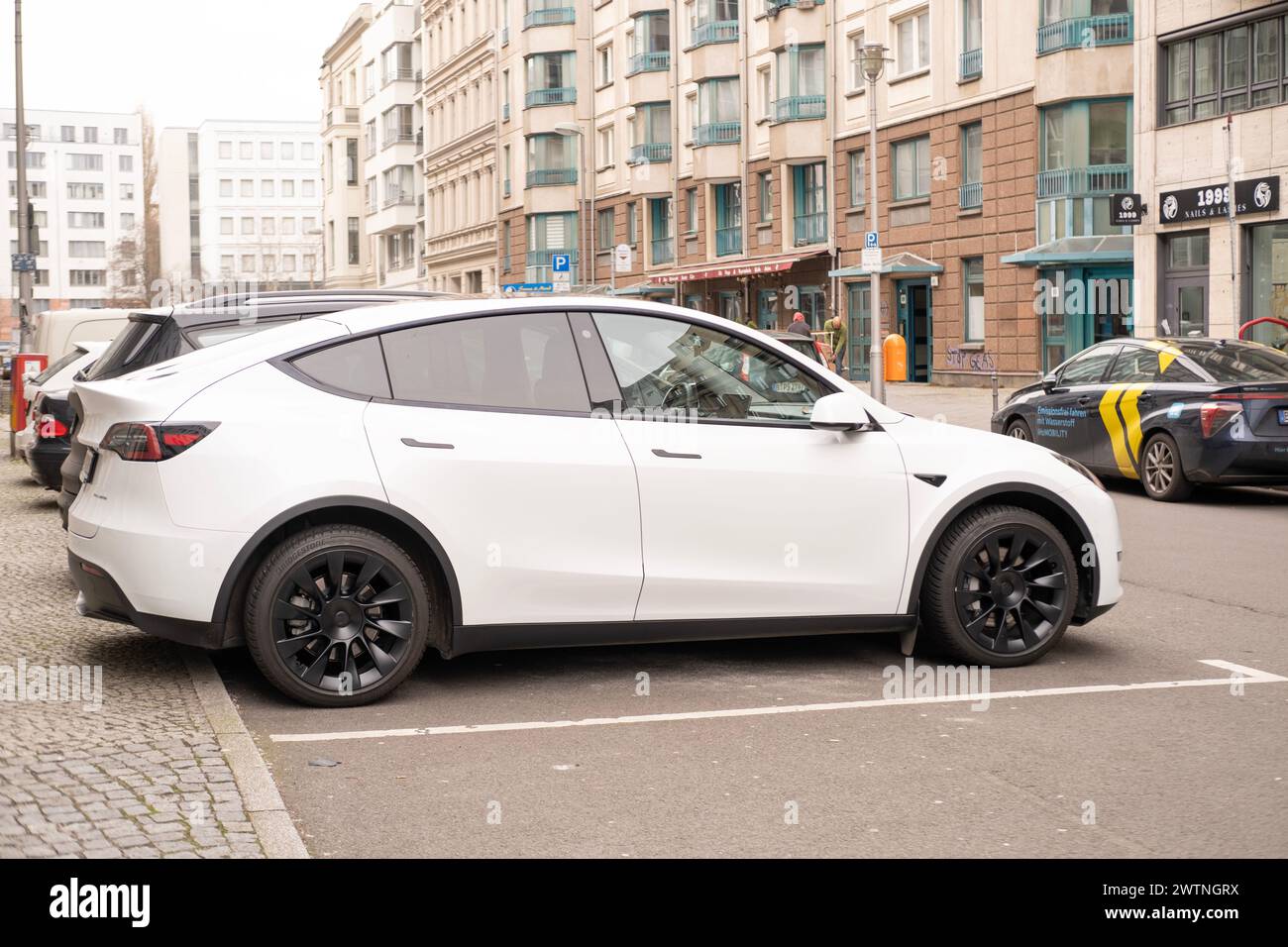 Weißes Tesla Model y Auto auf der Straße von Berlin, umweltfreundliches Fahrzeug in der städtischen Umwelt, nachhaltiger Transport, neueste Technologien in der Automobilindustrie Stockfoto