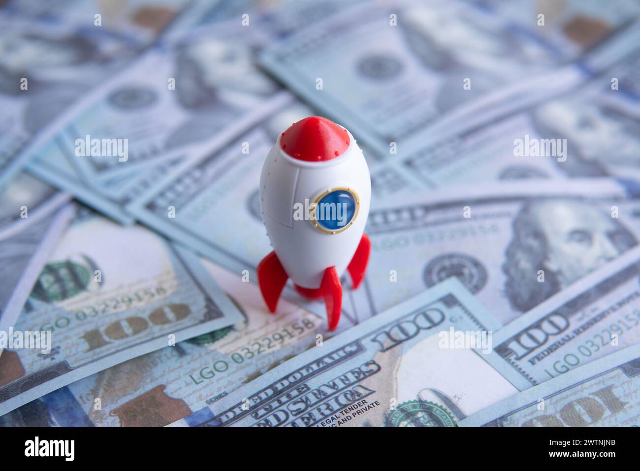 Nahaufnahme von Raketenraumschiff und Geld. Unternehmensgründung, -Start und -Boost-Konzept. Stockfoto