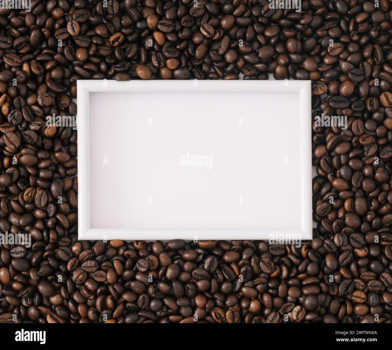 Geröstete Kaffeebohnen im Hintergrund mit weißem Rahmen Kopierraum. Minimales Konzept und Einfachheit. Kaffee-ästhetischer Hintergrund. Flache Lage, Ansicht von oben. Stockfoto
