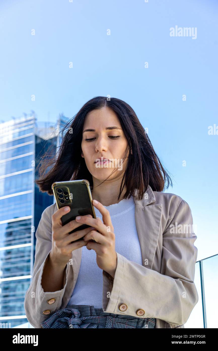 Tiefwinkelansicht einer schönen Frau, die eine Nachricht auf ihrem Smartphone schreibt. Kopierbereich. Stockfoto