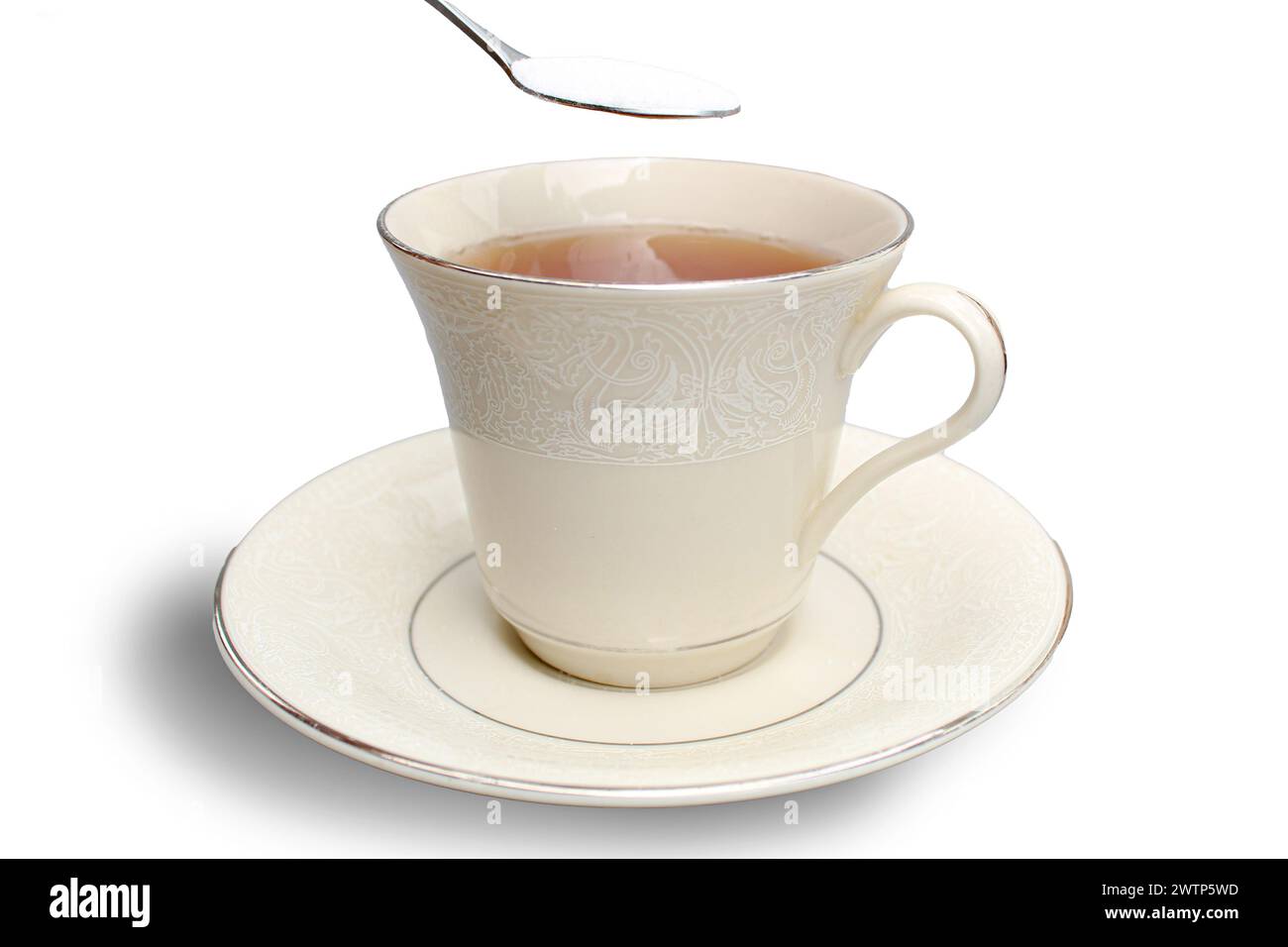 Fügen Sie einen Teelöffel Zucker in eine Tasse Tee auf weißem Hintergrund. Stockfoto