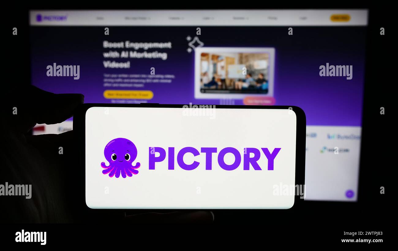 Person, die ein Mobiltelefon mit dem Logo der US-amerikanischen Videoproduktionsfirma Pictory Corp. Vor der Unternehmenswebseite hält. Schwerpunkt auf dem Display des Telefons. Stockfoto