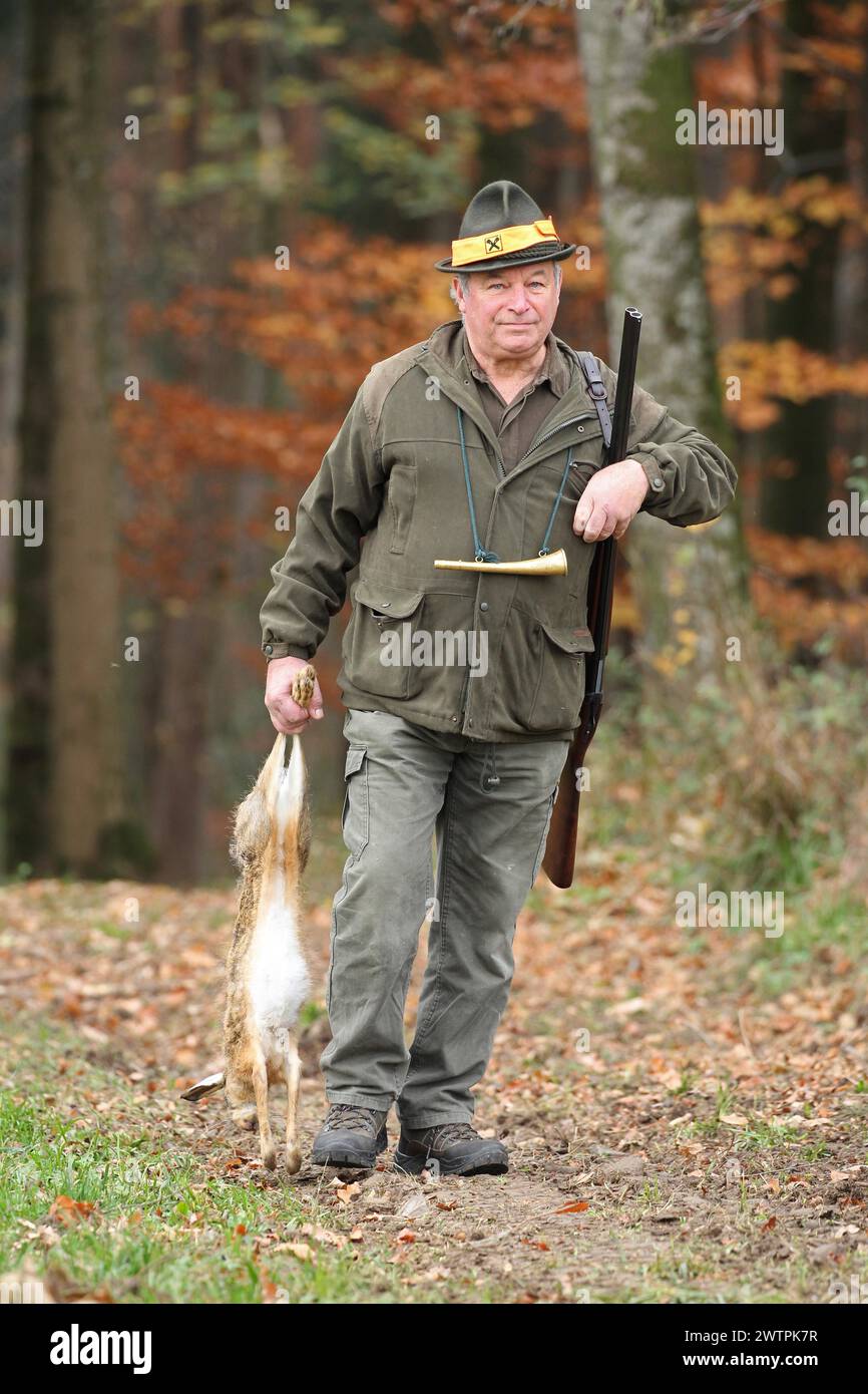 Jäger mit einem Hasen (Lepus europaeus) Niederösterreich, Österreich Stockfoto