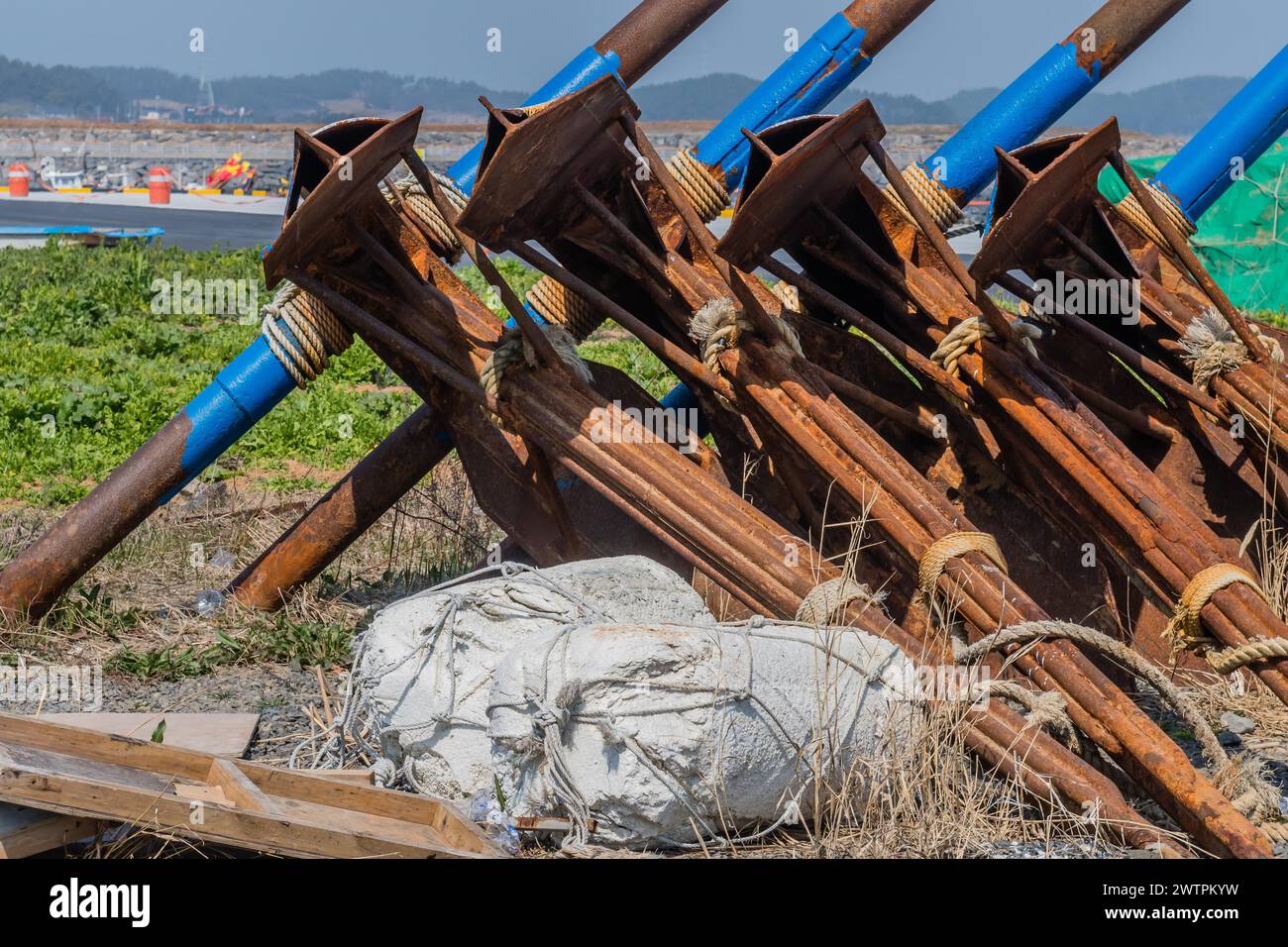 Rostige Anker und blaue Rohre in einem Baugebiet mit Schutt an einem sonnigen Tag in Seocheon, Südkorea Stockfoto