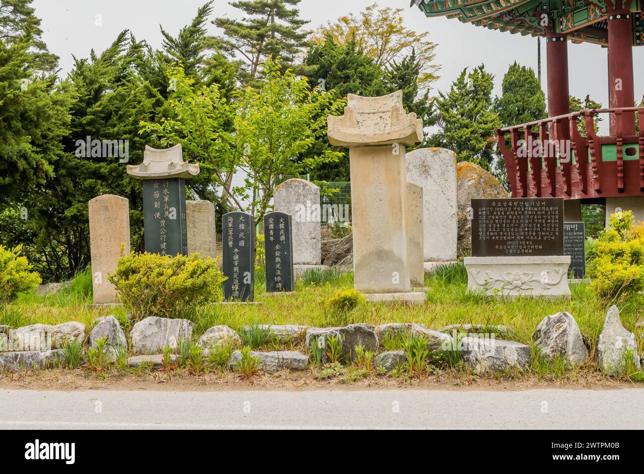 Alte Grabsteine in einer ruhigen Umgebung mit traditioneller asiatischer Architektur in Sinjin-Do, Südkorea Stockfoto