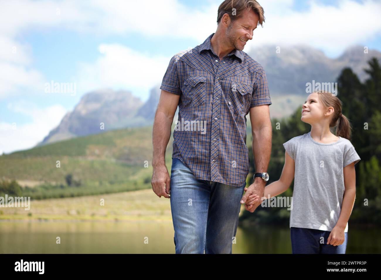 Vater, Tochter und Hände an einem See halten, in der Natur oder Camping mit Urlaub, Reise und Familie verbringen. Liebe, Unterstützung und Vertrauen, Mann und Stockfoto