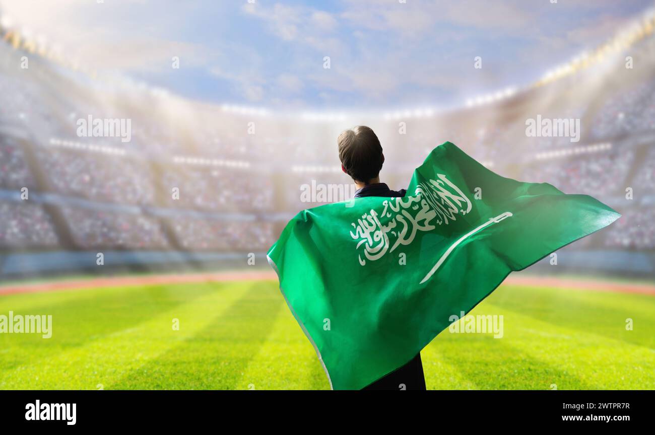 Saudi-Arabien-Football-Unterstützer im Stadion. Saudische Fans auf dem Fußballfeld beobachten das Spiel der Mannschaft. Gruppe von Fans mit Flagge und Nationaltrikot c Stockfoto