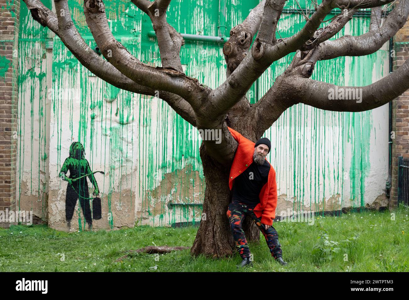 Am 18. März 2024 bewundert die Öffentlichkeit ein neues Kunstwerk des mysteriösen Künstlers Banksy an der Hornsey Road im Norden Londons. Das neue Stück erschien am Wochenende, aber heute beanspruchte der Künstler die Anerkennung für dieses neueste Werk - ein grünes Spray auf einer Wohnwand hinter einem getrimmten Baum, der wie Laub aussieht, mit einer Schablone einer Person, die einen Druckschlauch daneben hält. Stockfoto