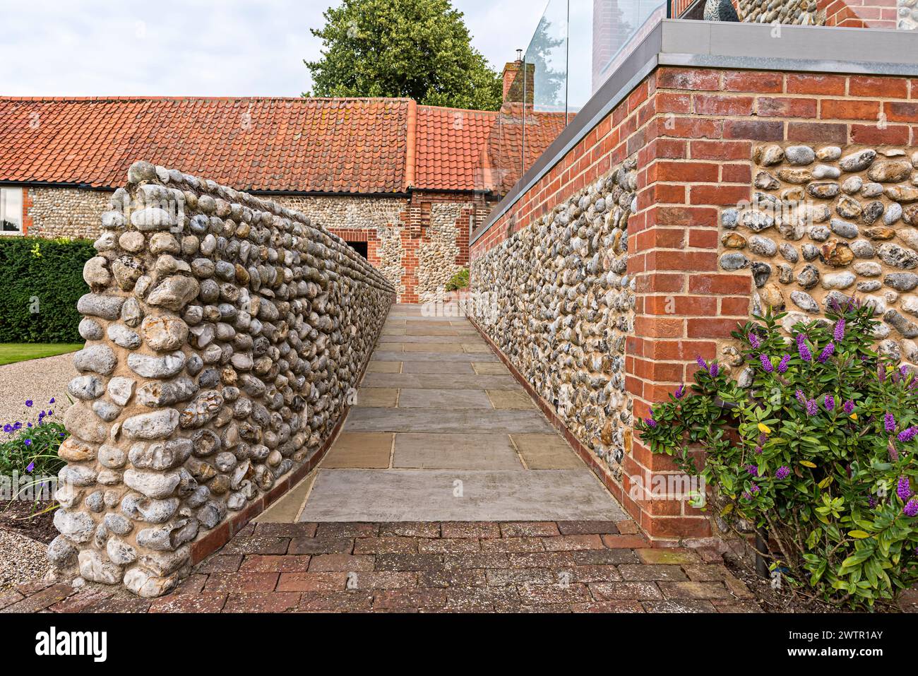 Steine in Beton in Ziegelstein vor dem Haus an der Küste in Blakeney, Norfolk, Großbritannien Stockfoto
