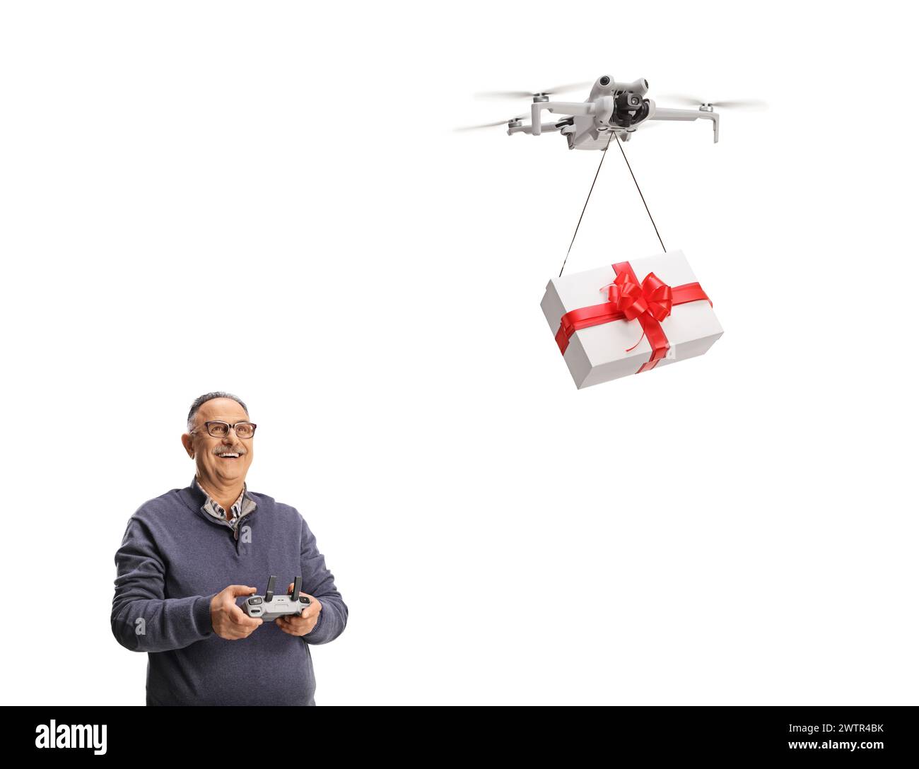 Glücklicher reifer Mann, der eine Geschenkbox mit einer Drohne auf weißem Hintergrund liefert Stockfoto