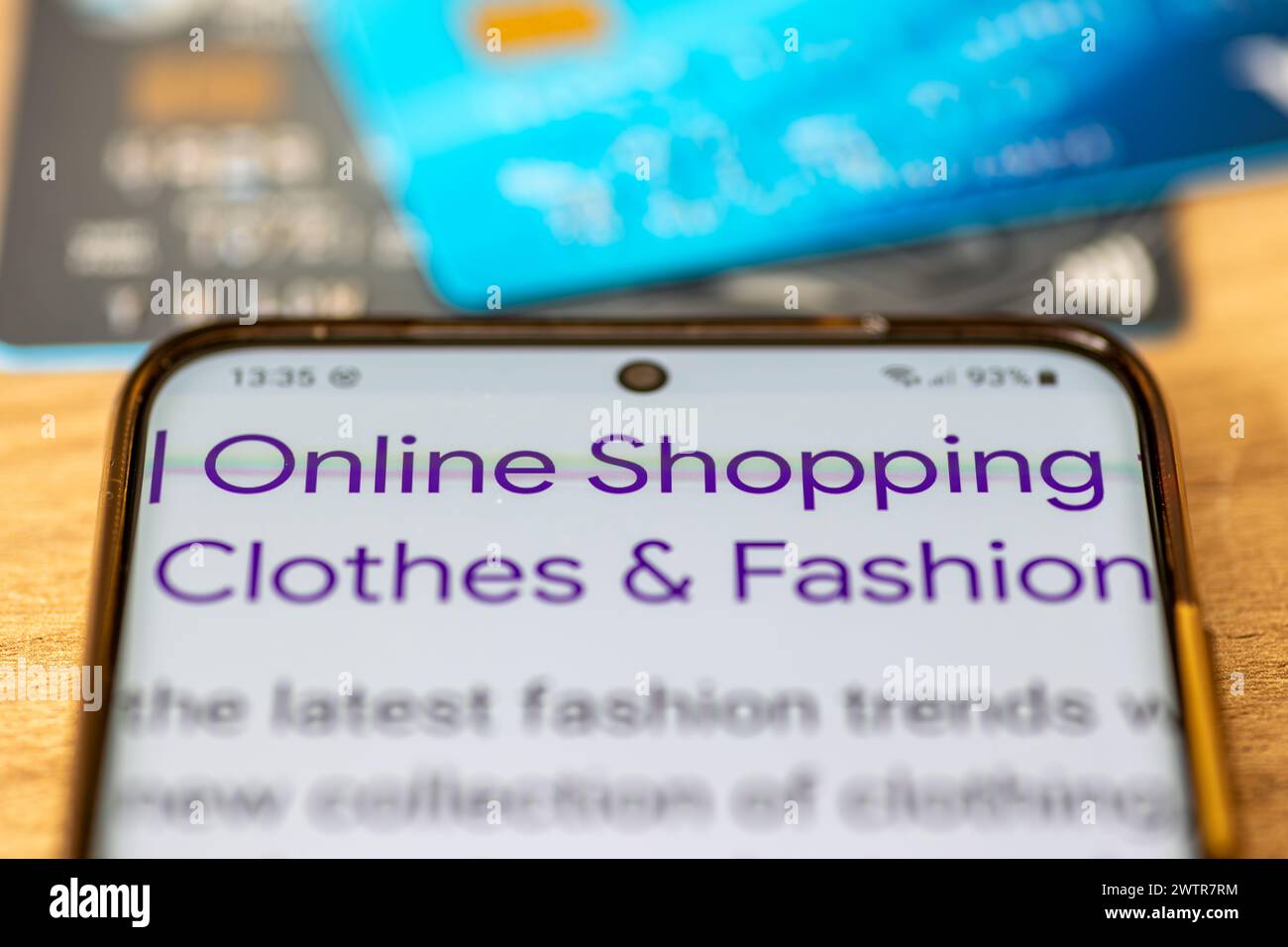 Eine Nahaufnahme eines Smartphones mit den Worten Online-Shopping, Kleidung und Mode und Bankkarte. Ein Online-Shopping-Konzept Stockfoto