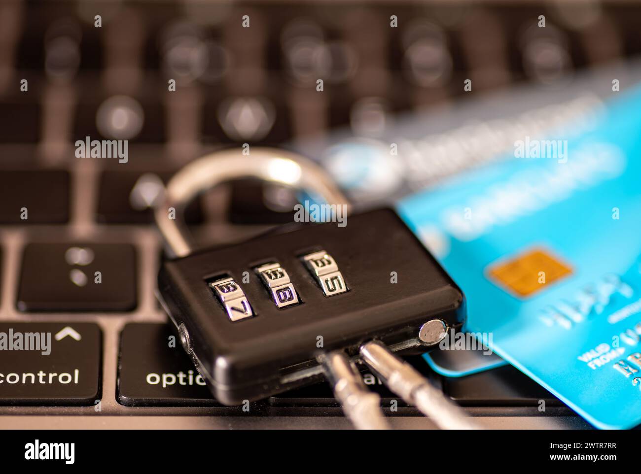 Ein Sicherheitskonzept für Online-Zahlungen mit einer Kombination aus Vorhängeschloss und Kredit-, Debitkarten auf der Tastatur eines Laptops. Stockfoto