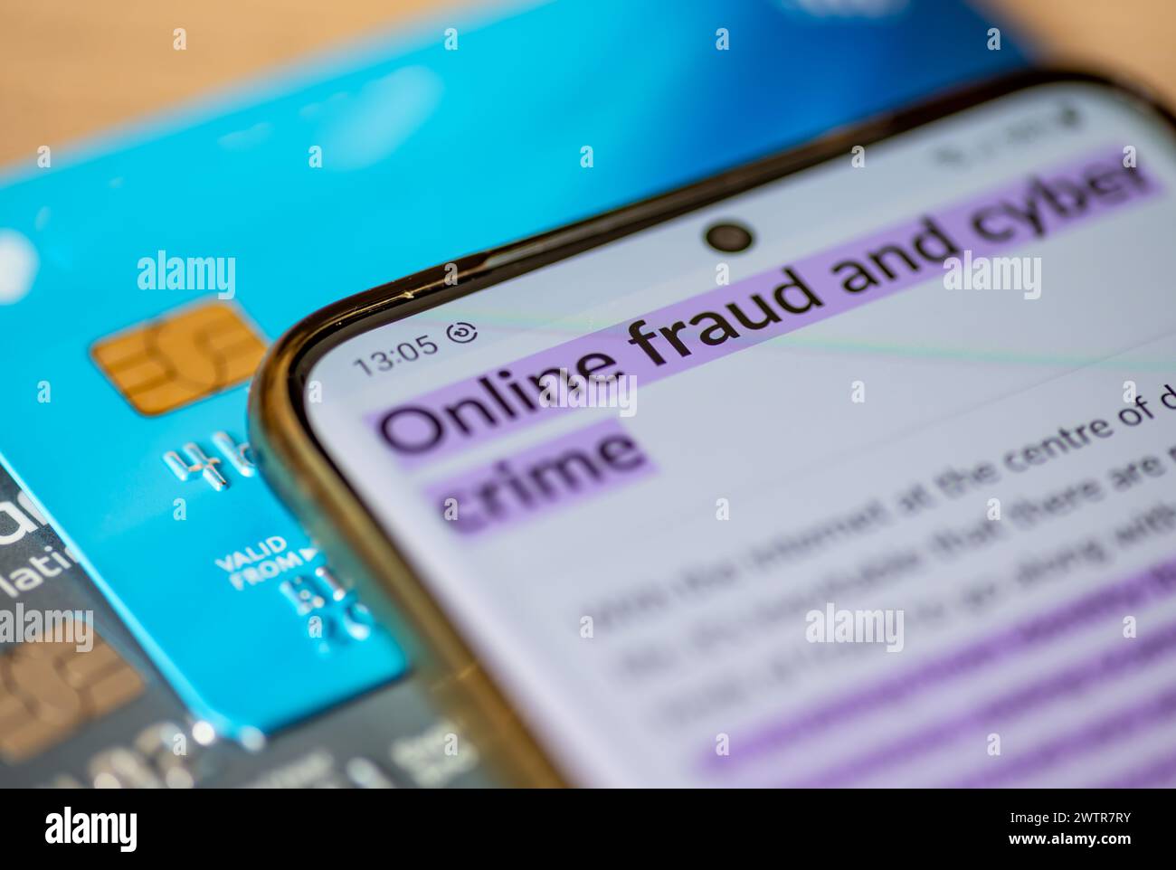 Ein Konzept für Online-Betrug und Cyberkriminalität mit einem Smartphone, auf dem die Wörter Online-Betrug und Cyberkriminalität auf Bankkarten stehen. Stockfoto