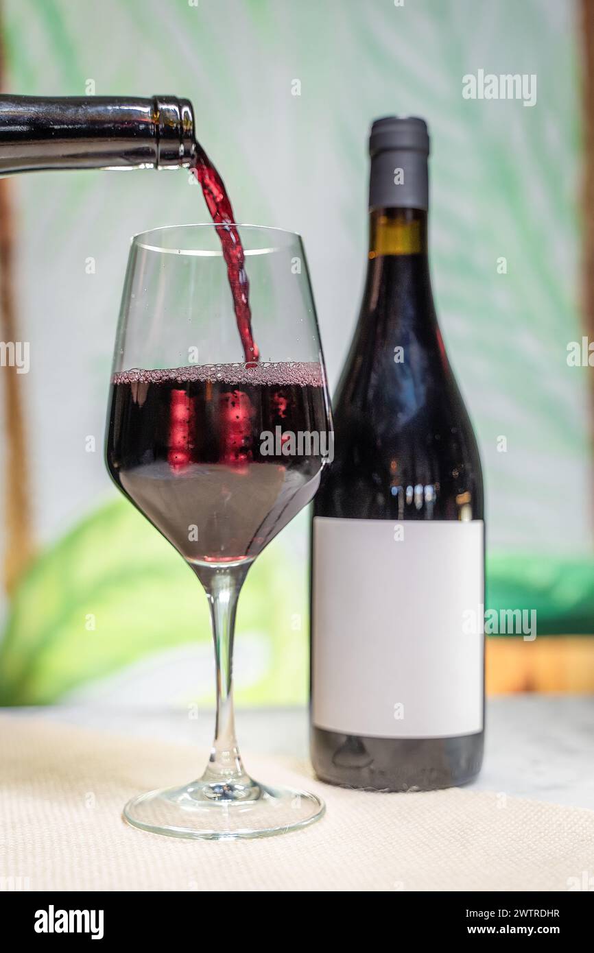 Wein wird zum Gießen in ein Glas gegossen Stockfoto