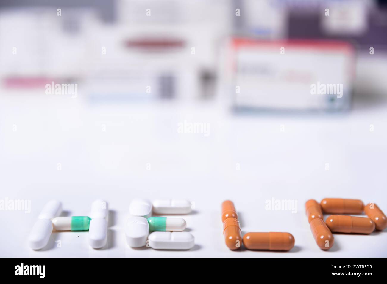 Wort HILFE gemacht mit medizinischen Pillen und im Hintergrund mehrere Kisten von Medikamenten. Stockfoto