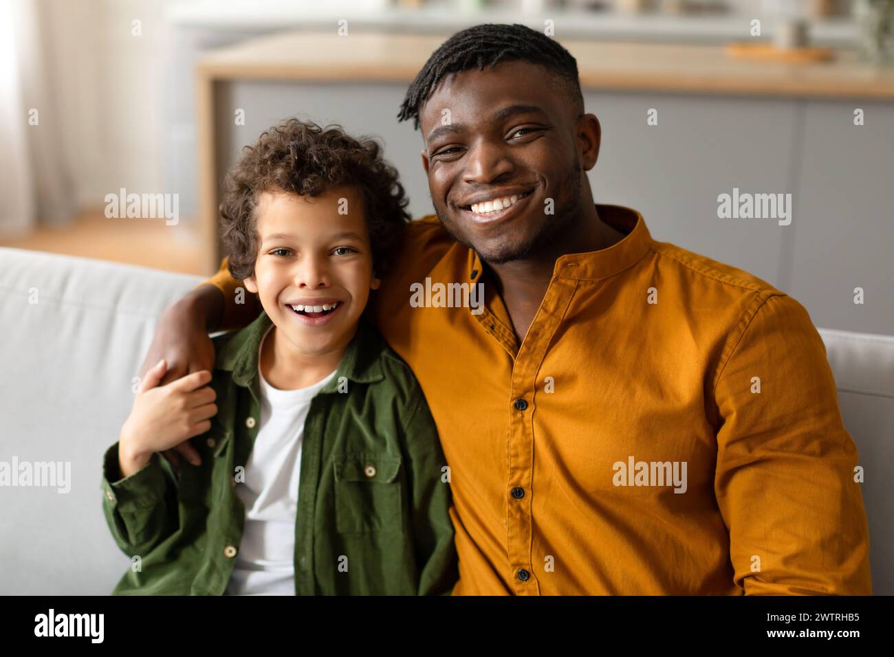 Vater und Sohn lächeln und umarmen zu Hause Stockfoto